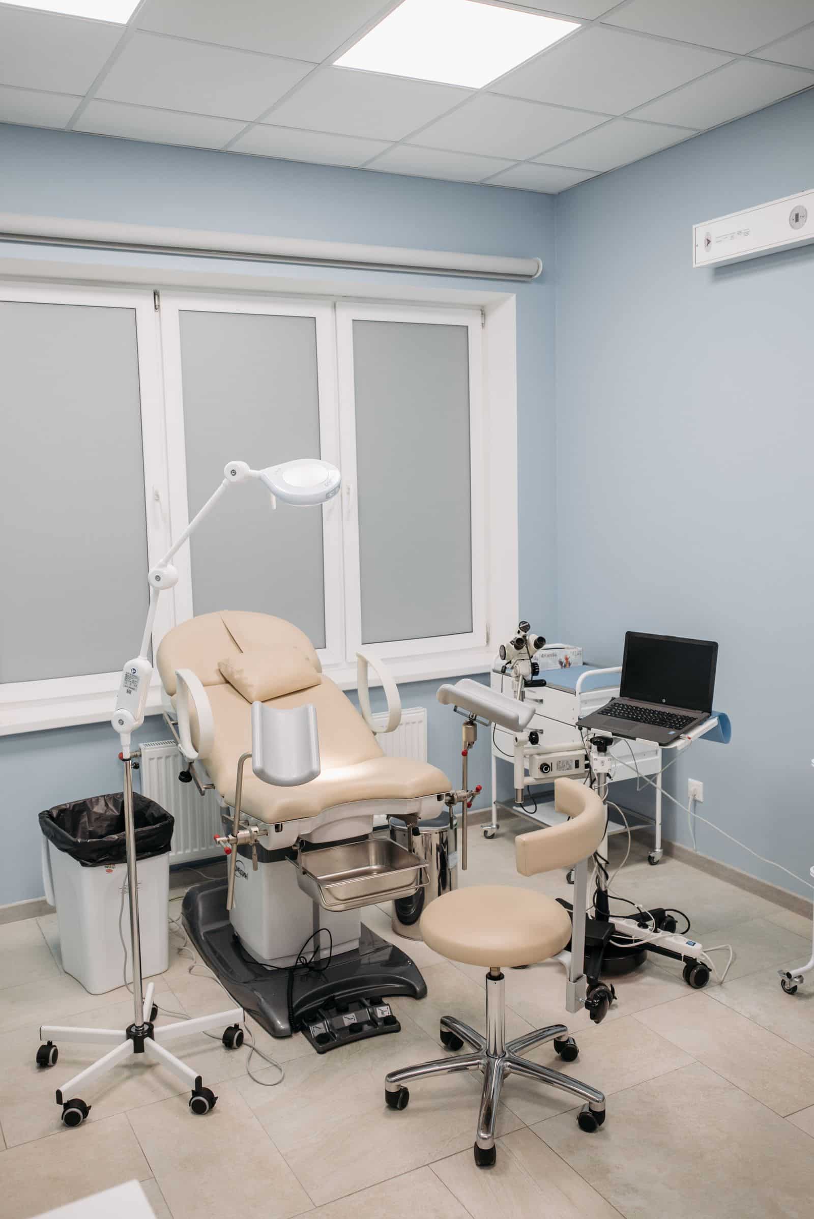 An unoccupied examination room with a pale blue wall.