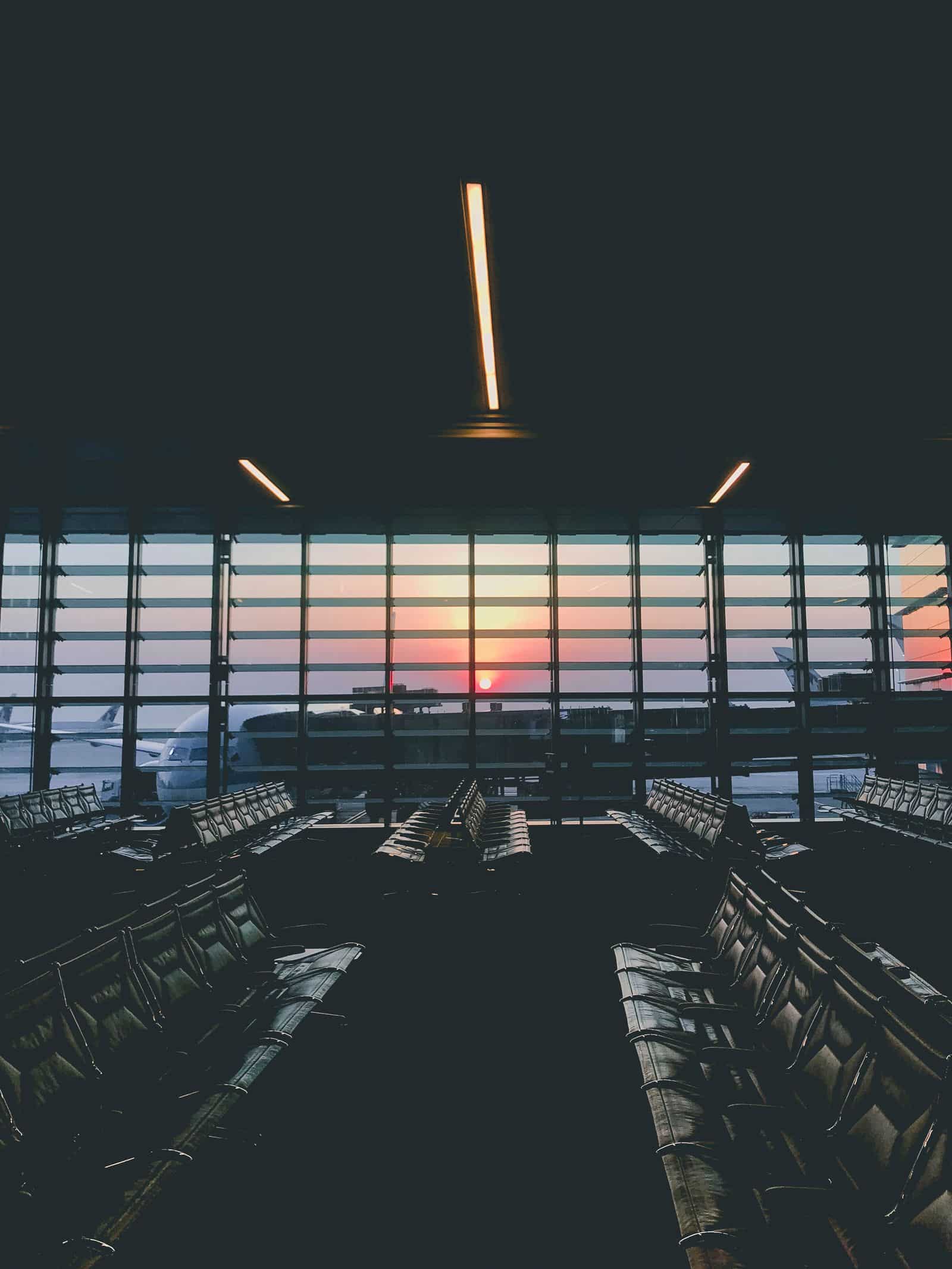An empty airport departure gate at dusk.